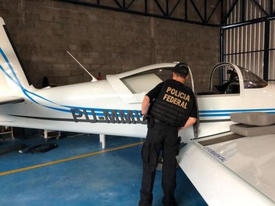 Policial observa aeronave apreendida durante operao Flak     (Polcia Federal/divulgao)