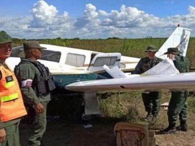 Policiais ao lado da aeronave que era ocupada pelos suspeitos. (Foto: Elpitazo)