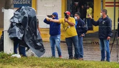 Acorrentado a poste e embaixo de lona, homem  entrevistado por jornalistas paraguaios (Foto: Capitn Bado.com)