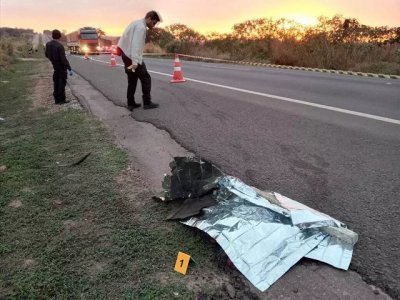 Corpo em estrada e peritos realizando procedimentos em local do crime (Foto: Sidney Assis, de Coxim)