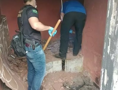 Policiais civis cavando cama de concreto onde ossada foi encontrada. (Foto:Divulgao/Polcia Civil)