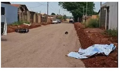 Corpo, motocicleta e capacete da vtima cados na rua onde crime aconteceu (Foto: Noticidade)