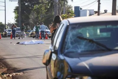 Corpo da vtima coberto por lenol na avenida. (Foto: Henrique Kawaminami)