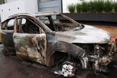 Carro queimado em frente  delegacia. (Foto: Henrique Kawaminami)