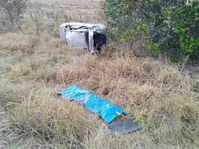 Carro destrudo em vegetao e corpo da vtima coberto. (Foto: Campo Grande News)