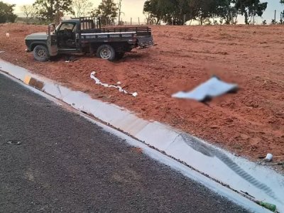 Corpo da vtima coberto por lenol s margens da estrada. (Foto: Coxim Agora)