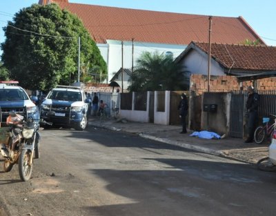 Corpo de homem assassinado a tiros fica ca�do em frente a resid�ncia, em rua isolada pela pol�cia (Foto: O Correio News)